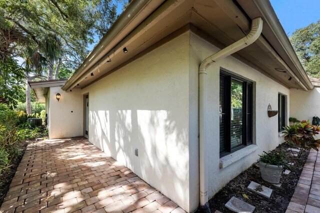 view of side of home with cooling unit and a patio