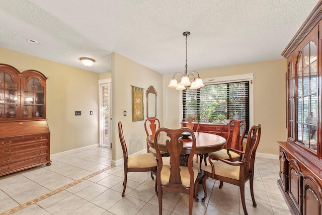 tiled dining area with a textured ceiling and a notable chandelier