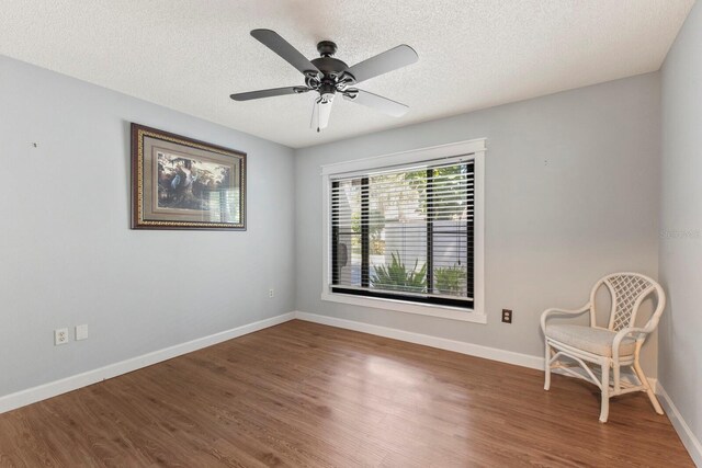 unfurnished room with dark wood-type flooring, a textured ceiling, and ceiling fan