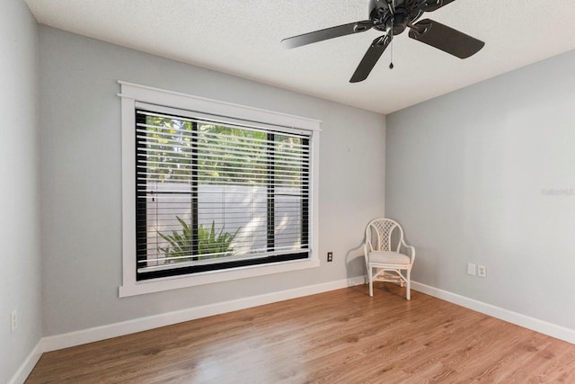 empty room featuring ceiling fan, light hardwood / wood-style floors, and a textured ceiling