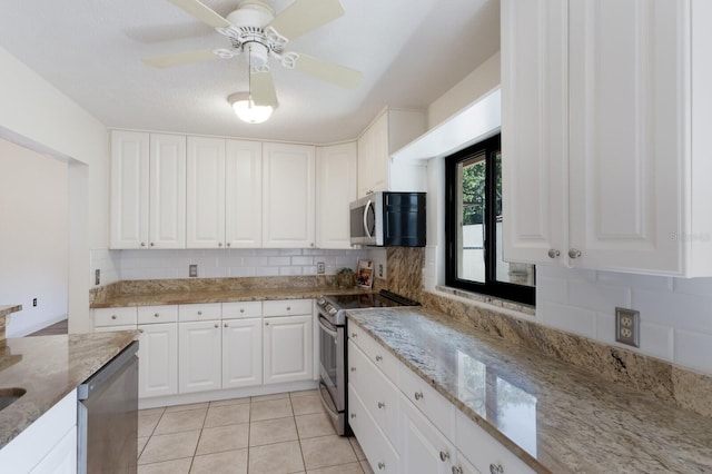 3601 Quail Hollow Ln, Bradenton, FL 34210 - kitchen featuring appliances with stainless steel finishes, backsplash, white cabinetry, light stone countertops, and light tile patterned floors