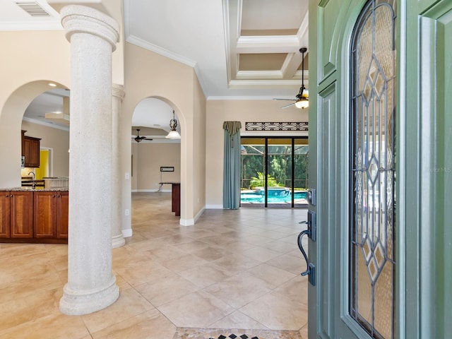 tiled entryway with ornate columns, ceiling fan, ornamental molding, and sink