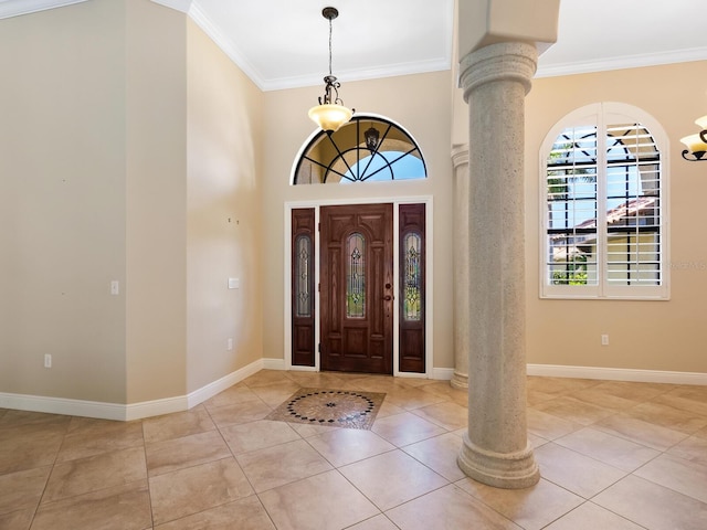 entrance foyer with light tile patterned floors, ornate columns, and ornamental molding