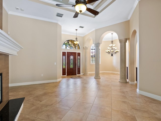 tiled entryway with ceiling fan with notable chandelier, crown molding, and decorative columns