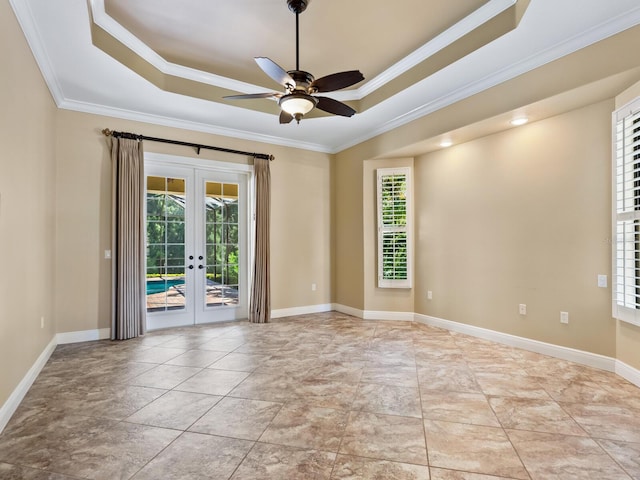 empty room with french doors, a raised ceiling, plenty of natural light, and ornamental molding