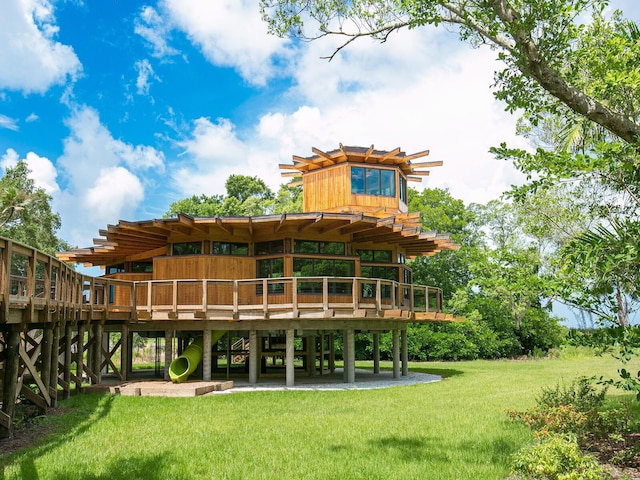 rear view of house featuring a yard and a deck