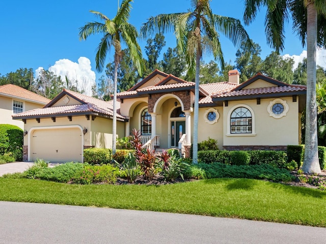 mediterranean / spanish-style house with a garage and a front lawn