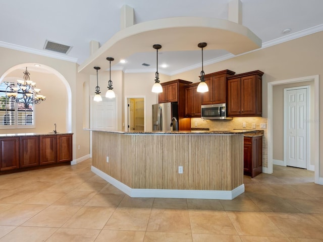 kitchen with pendant lighting, dark stone countertops, an island with sink, a notable chandelier, and stainless steel appliances