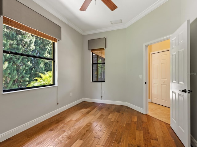 unfurnished room featuring light wood-type flooring, ceiling fan, and crown molding