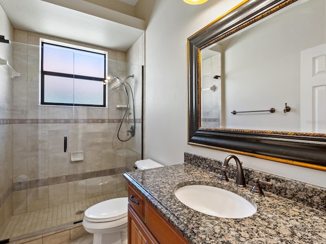 bathroom with vanity, toilet, and a shower with shower door