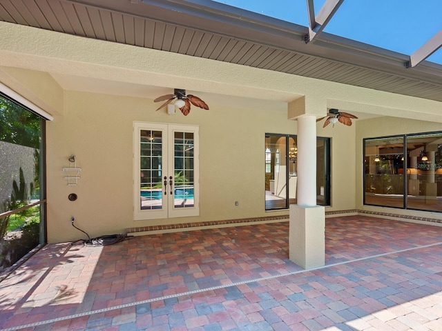 view of patio / terrace featuring french doors, glass enclosure, and ceiling fan