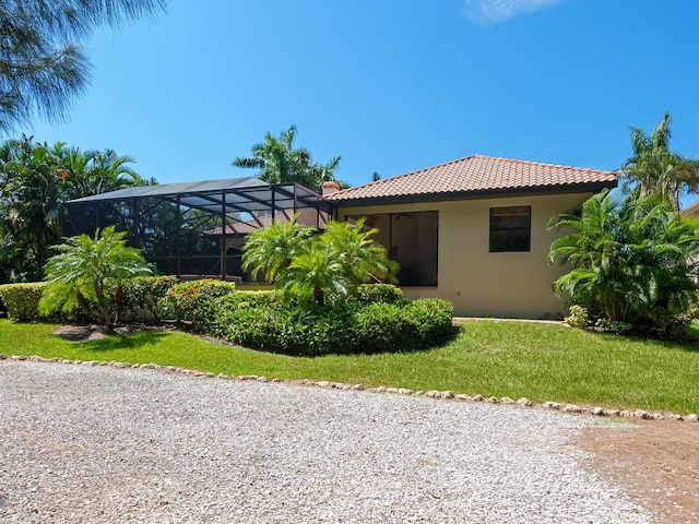 view of front of property featuring a lanai and a front lawn