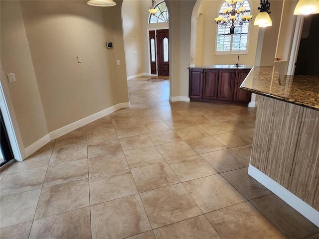 tiled foyer with sink and a chandelier