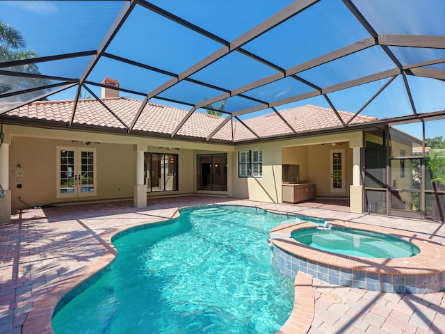 view of swimming pool with french doors, an in ground hot tub, ceiling fan, glass enclosure, and a patio area