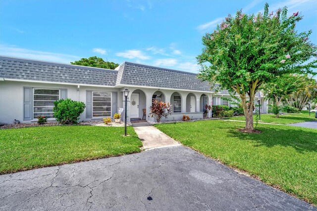 single story home featuring a front lawn