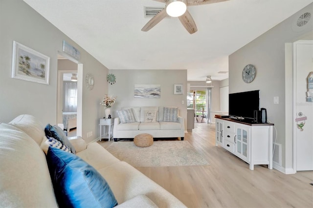 living room with light hardwood / wood-style flooring and ceiling fan