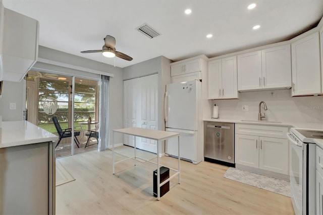 kitchen featuring light wood-type flooring, white appliances, sink, and ceiling fan