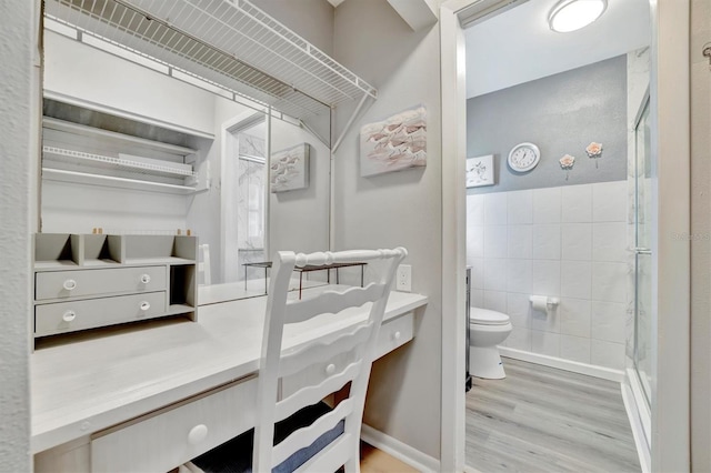 bathroom with vanity, walk in shower, tile walls, toilet, and hardwood / wood-style flooring