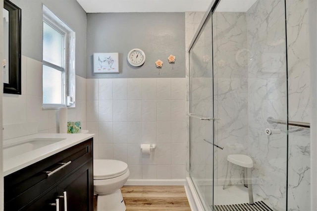 bathroom featuring tile walls, toilet, a wealth of natural light, and wood-type flooring