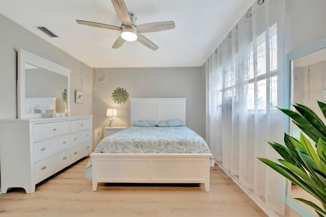 bedroom with light hardwood / wood-style flooring, ceiling fan, and multiple windows