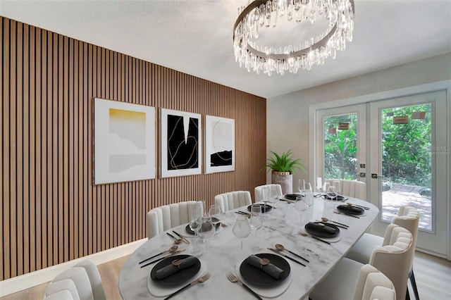 dining room with light hardwood / wood-style flooring, a chandelier, and french doors