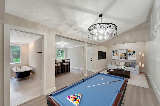 game room featuring wood-type flooring, a textured ceiling, and indoor bar