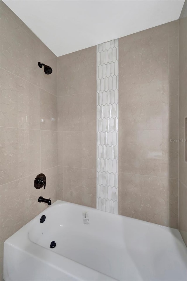 bathroom featuring tiled shower / bath