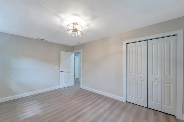 unfurnished bedroom with a closet and light hardwood / wood-style floors