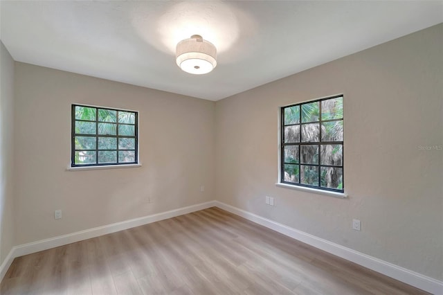 empty room with light hardwood / wood-style floors and a wealth of natural light