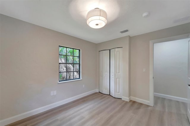 unfurnished bedroom featuring a closet and light hardwood / wood-style floors