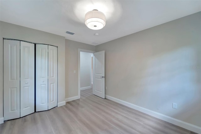 unfurnished bedroom featuring light hardwood / wood-style floors and a closet