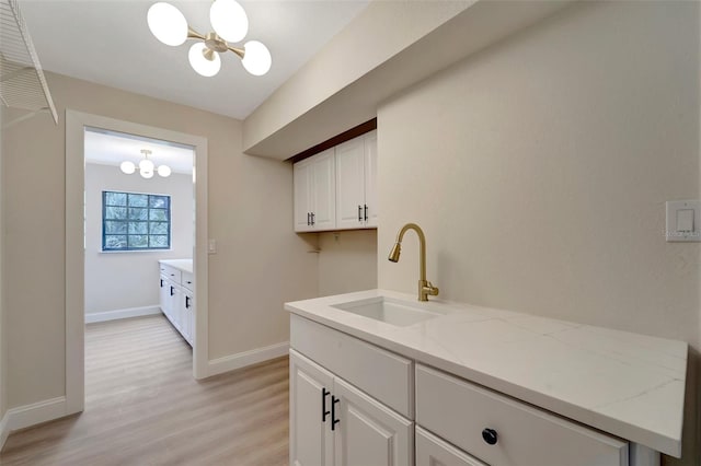 interior space featuring sink, light hardwood / wood-style flooring, and a chandelier