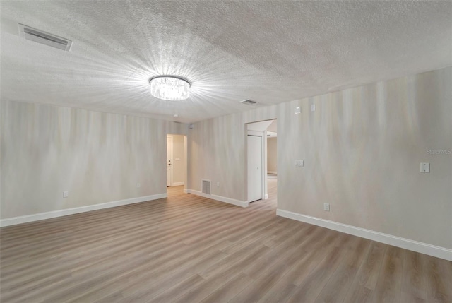 unfurnished room featuring a textured ceiling and hardwood / wood-style floors