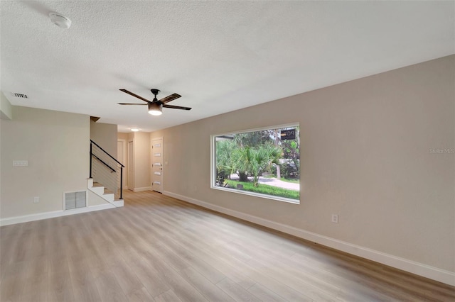 unfurnished room featuring light hardwood / wood-style flooring, ceiling fan, and a textured ceiling