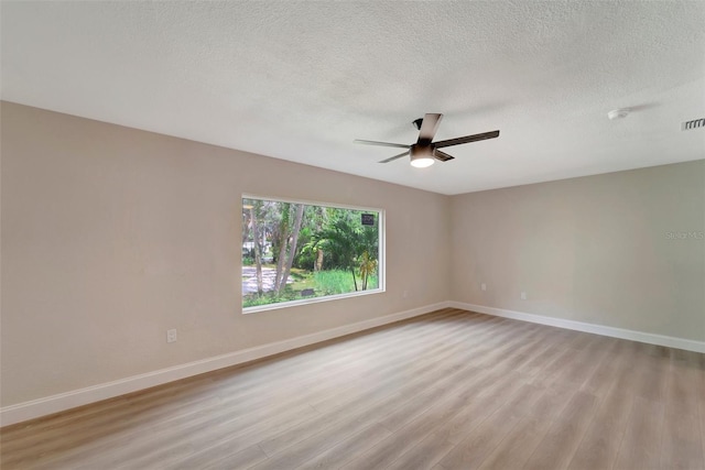 unfurnished room with a textured ceiling, light hardwood / wood-style floors, and ceiling fan