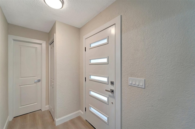 entryway featuring a textured ceiling and light wood-type flooring