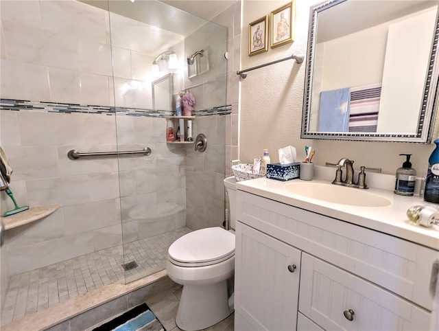 bathroom featuring tiled shower, vanity, and toilet