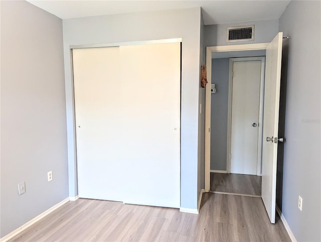 unfurnished bedroom with a closet and light hardwood / wood-style flooring