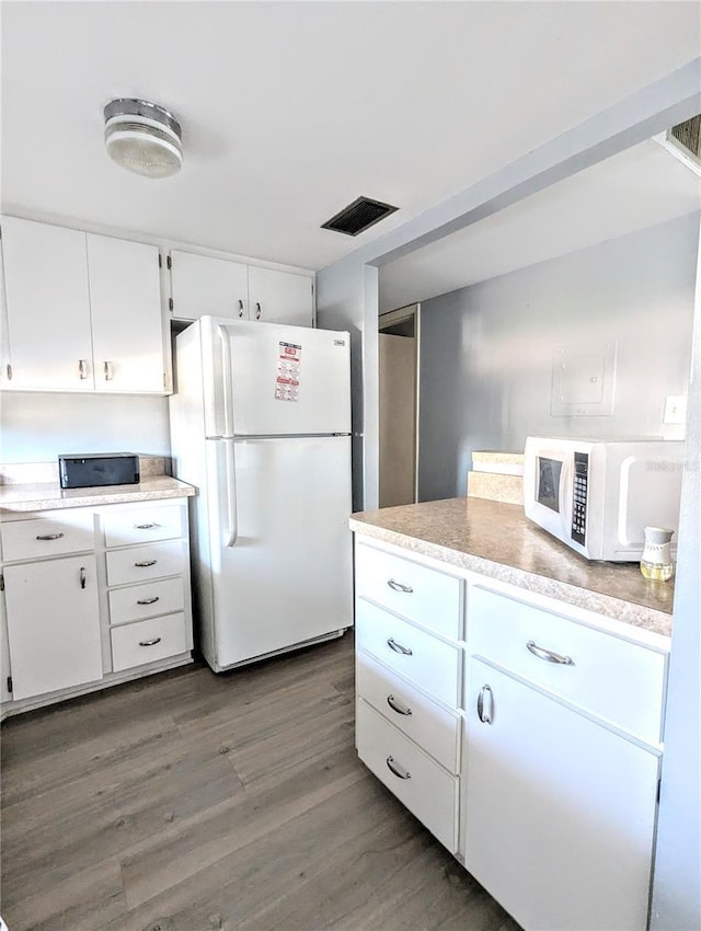 kitchen featuring white cabinetry, dark wood-type flooring, and white appliances