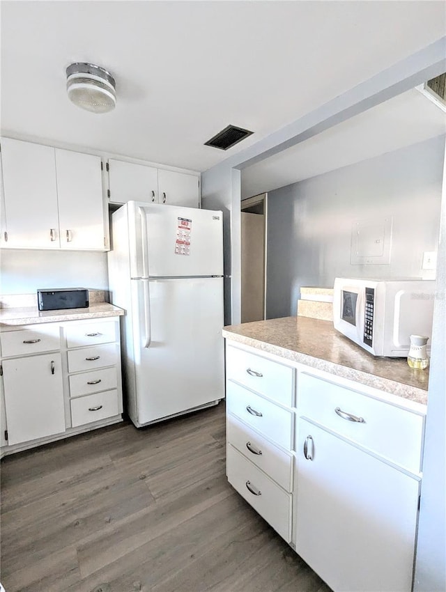5933 17th St W Unit A24, Bradenton, FL 34207 - kitchen featuring white appliances, wood finished floors, light countertops, and white cabinetry