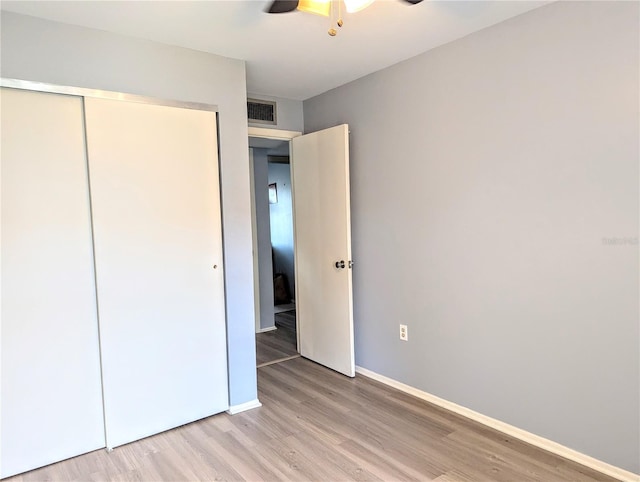 unfurnished bedroom featuring ceiling fan, a closet, and light hardwood / wood-style flooring