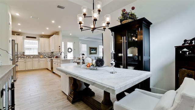 dining area featuring light hardwood / wood-style floors and a notable chandelier