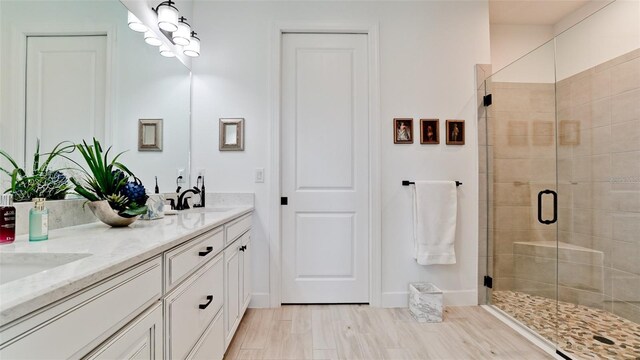 bathroom featuring hardwood / wood-style floors, vanity, and a shower with shower door