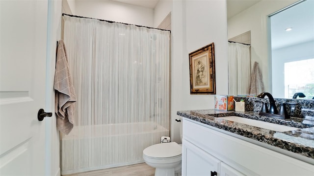 full bathroom featuring hardwood / wood-style floors, vanity, shower / bath combination with curtain, and toilet