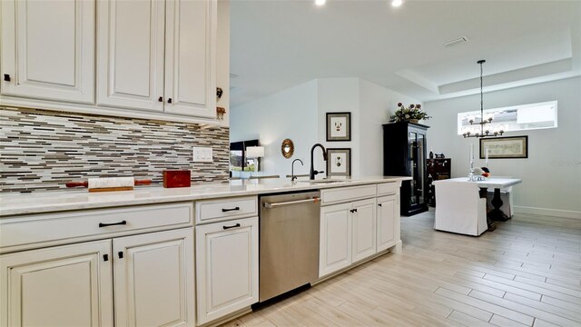 kitchen featuring dishwasher, an inviting chandelier, sink, light hardwood / wood-style flooring, and decorative light fixtures