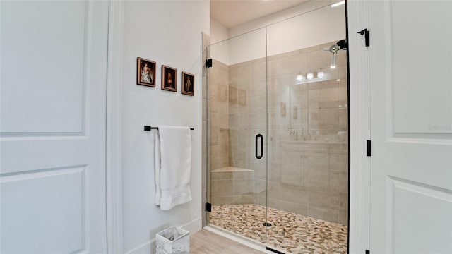 bathroom featuring hardwood / wood-style flooring and a shower with door