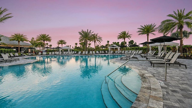 pool at dusk with a patio