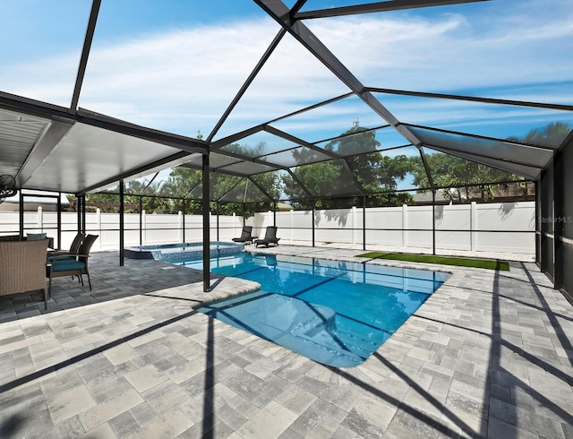 view of pool with a patio and glass enclosure