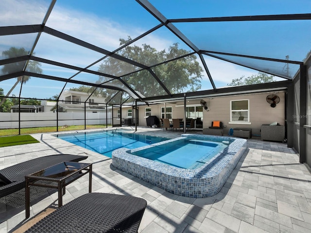 view of pool with glass enclosure, a patio area, and an in ground hot tub