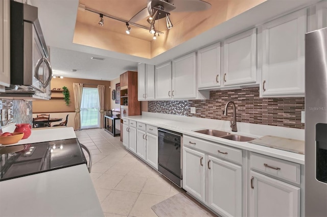 kitchen featuring white cabinetry, a tray ceiling, black appliances, and sink